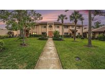 Charming two-story townhome showcasing landscaped front yard, manicured hedges, and a tile roof at 9521 86Th Ave # 9521, Seminole, FL 33777
