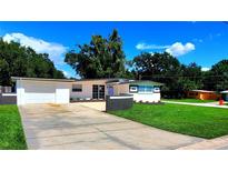 Charming one-story home featuring modern paint, green grass, and a spacious driveway at 1373 Fairfax Rd, Clearwater, FL 33764