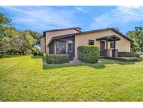 Well-maintained home exterior with a lush lawn, mature trees, and tidy landscaping on a bright sunny day at 1400 Tarpon Woods Blvd # A4, Palm Harbor, FL 34685
