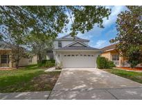Charming two-story home featuring an attached two-car garage and mature trees at 20109 Bay Cedar Ave, Tampa, FL 33647