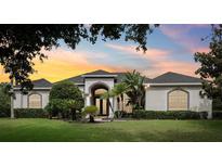 Stunning home exterior with lush landscaping, arched entryway, and a well-manicured lawn at 2708 Coastal Range Way, Lutz, FL 33559