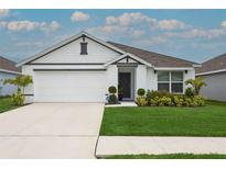 Charming one-story home features a two-car garage, well-manicured lawn, and classic white exterior at 5687 Barakat Rd, Zephyrhills, FL 33541