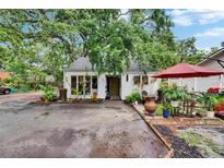 Charming single story home showcasing fresh white paint, verdant landscaping, and a inviting yellow front door at 675 64Th S Ave, St Petersburg, FL 33705