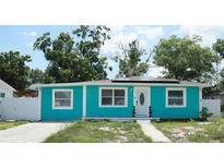 Charming turquoise single-story home featuring bright trim, updated windows, and solar panels at 7510 N Tampania Ave, Tampa, FL 33614