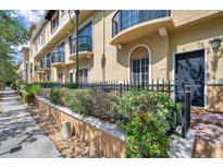 Charming townhome featuring a landscaped front yard and wrought iron fence at 113 S Sherrill St # 113, Tampa, FL 33609