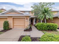 Inviting exterior of a two-story home with a well-manicured lawn, beautiful shrubs, and a palm tree at 11546 52Nd E Ct, Parrish, FL 34219