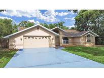 Charming single-story home with a two-car garage and well-maintained lawn at 13094 Huntington Woods Ave, Spring Hill, FL 34609