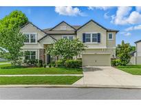 Charming two-story home featuring a manicured lawn, beautiful landscaping, and a two-car garage at 18696 Malinche Loop, Spring Hill, FL 34610