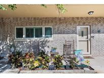 Charming brick condo exterior featuring rocking chairs, colorful plants, and a welcoming front door at 2192 Swedish Dr # 10, Clearwater, FL 33763