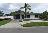 Charming single-story home with a cozy carport and beautiful mature palm tree at 2470 Del Rio Way, Dunedin, FL 34698