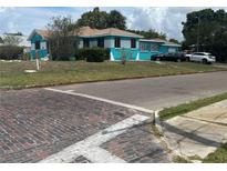 Charming turquoise and white home with brick street and lush lawn at 2701 W Cherry St, Tampa, FL 33607