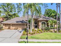 Charming single-story home featuring a three-car garage, tile roof, and meticulously maintained landscaping at 5029 Camberley Ln, Oldsmar, FL 34677