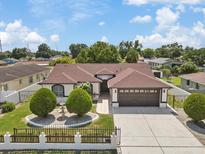 Charming single-story home with a well-maintained lawn, mature trees, and a brown roof at 5812 Blossom Ave, Tampa, FL 33614
