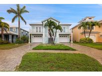 Charming two-story coastal home with dual garages, balconies, palm trees, and well-manicured landscaping at 6416 Grenada Island Ave, Apollo Beach, FL 33572