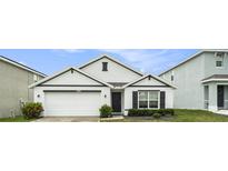 Charming single-story home with a well-manicured lawn, white siding, and a two-car garage, perfect for families at 7639 Broad Pointe Dr, Zephyrhills, FL 33540