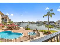 A luxurious pool and spa area overlooks a scenic waterfront with boat docks at 105 Island Way # 126, Clearwater Beach, FL 33767