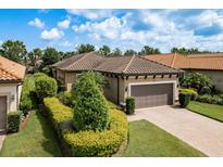 Charming home featuring a tile roof, manicured landscaping, a brick driveway and an attached two car garage at 11551 Callisia Dr, Odessa, FL 33556