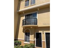 Two-story condo featuring a balcony with seating and black doors at 125 Grand Beach Pl # 125, Tampa, FL 33609