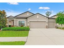 Charming single Gathering home featuring a well-manicured lawn and a spacious three-car garage at 18620 Rococo Rd, Spring Hill, FL 34610