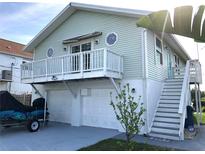 Two-story coastal home featuring a balcony, two-car garage, and stairs to the main level at 3312 Holly Springs Dr, Hernando Beach, FL 34607