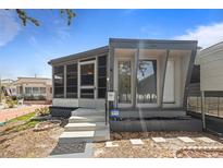 Cozy single-story home with a screened-in porch and modern gray and white exterior at 4851 W Gandy Blvd # B1L8, Tampa, FL 33611