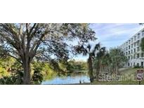 Building exterior overlooking the lake, highlighted by mature trees, offering a serene view and natural light at 701 S Madison Ave # 515, Clearwater, FL 33756