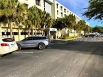 Attractive building with palm trees providing shade for parked cars and pedestrians at 701 S Madison Ave # 515, Clearwater, FL 33756