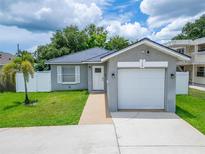 Charming single-story home featuring a well-maintained lawn, a one car garage, and freshly painted grey exterior at 719 58Th S St, Gulfport, FL 33707
