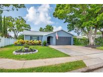 Charming single-story home featuring a well-manicured lawn, mature trees, and inviting curb appeal at 7444 119Th Ave, Largo, FL 33773
