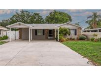Charming single-story home with well-maintained lawn, mature landscaping, and covered parking at 7503 Winchester Dr, Tampa, FL 33615