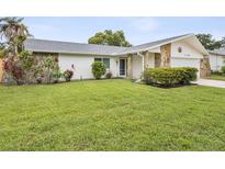 Charming single-story home with stone accents and a well-maintained lawn at 11762 Barb Ct, Seminole, FL 33778