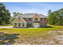 Spacious two-story home featuring well-manicured landscaping and ample curb appeal at 15420 Aubrey Ave, Spring Hill, FL 34610
