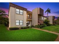 Inviting condo with manicured lawn and lush tropical landscaping at sunset at 2400 Winding Creek Blvd # 4-101, Clearwater, FL 33761