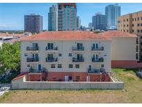 Condo building with a terracotta tile roof and multiple balconies, set against a city skyline backdrop at 340 1St N St # I, St Petersburg, FL 33701