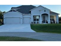 Charming single-story home with manicured lawn and a three-car garage, perfect curb appeal at 3895 Tate Ct, North Port, FL 34288