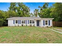 Charming single-story home featuring a well-manicured lawn, blue shutters, and inviting curb appeal at 3906 W Rogers Ave, Tampa, FL 33611