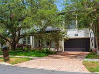 Elegant two-story home with a brick driveway and mature trees enhancing its curb appeal at 4313 W Vasconia St, Tampa, FL 33629