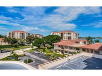 An aerial view of a building complex with parking, landscaping and waterway views under a sunny sky at 6145 Sun Blvd # 404, St Petersburg, FL 33715