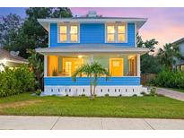 Charming blue two-story home with a cozy front porch and well-manicured lawn at dusk at 661 14Th S Ave, St Petersburg, FL 33701