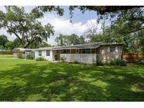 Charming single-story home features a large, grassy yard and a covered carport at 7240 Ottley St, Zephyrhills, FL 33541