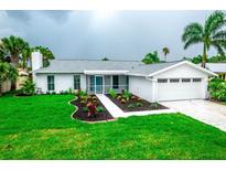 Charming single-story home with freshly landscaped yard, healthy green grass and an attached garage at 913 Spindle Palm Way, Apollo Beach, FL 33572