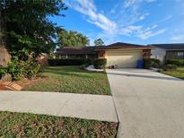 Charming single-story home featuring a manicured lawn and a spacious two-car garage at 1011 Mallow Way, Brandon, FL 33510