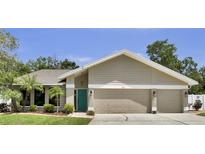 Charming single Gathering home showcasing a teal front door and well-manicured lawn at 12219 Steppingstone Blvd, Tampa, FL 33635