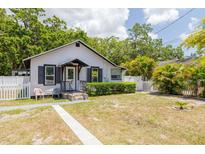 Charming cottage-style home with a well-manicured lawn and a classic white picket fence at 1235 Bass Blvd, Dunedin, FL 34698