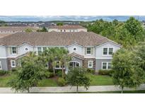 Inviting two-story home with a well-manicured lawn, stone accents, and a charming tiled roof at 13306 Wildgrass Trl, Odessa, FL 33556