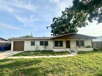 Charming single-story home with a cozy front porch, attached garage, and a lawn needing some TLC at 1559 78Th N Ter, St Petersburg, FL 33702