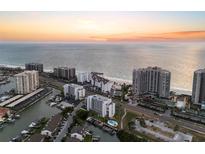Breathtaking aerial view of beachfront condos, marina, and shoreline at sunset at 1581 Gulf Blvd # 403N, Clearwater Beach, FL 33767