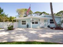 Charming single-story home with an inviting front porch, American flag, and pea gravel driveway at 1835 Michigan Ne Ave, St Petersburg, FL 33703
