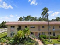 Inviting condo exterior featuring lush landscaping, covered walkways, and a well-maintained facade at 2003 Greenbriar Blvd # 1, Clearwater, FL 33763