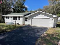 Charming single-story home featuring a two-car garage and well-maintained landscaping at 22365 Panorama St, Brooksville, FL 34601